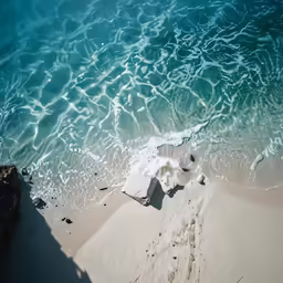 a sandy beach is covered in waves next to the ocean