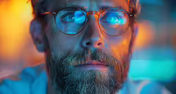 a close up shot of a man with blue glasses,this is a picture of a man with glasses