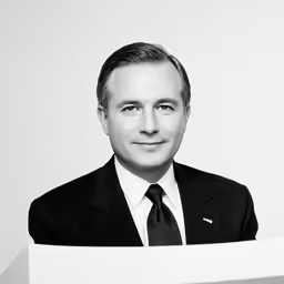 a black and white photo of a man in suit and tie