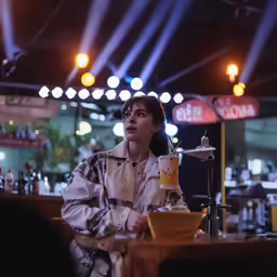 the woman is sitting at the bar by herself