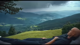 a man relaxing on a sofa looking at mountain range