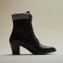 the heeled boot has two zippers and is made with black leather