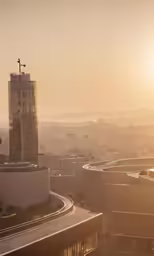 a sunset over a building and some other buildings