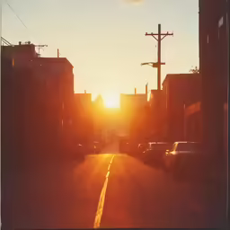 traffic is traveling through an empty street at sunset