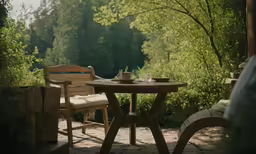the wood table is on the patio near a bench