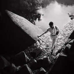 a woman climbing up a stone walkway by the water