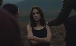 woman looking at the man behind her in a field
