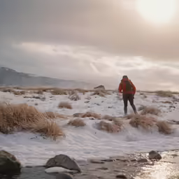 a person standing in the snow holding onto a kite