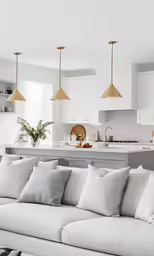 a white kitchen with white couches and light grey accents