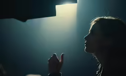 a woman giving a peace sign while sitting in front of a projection screen