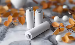 three electric batteries sitting next to small balls of leaves