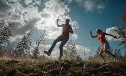 two people running in the grass and one of them is holding a baseball bat