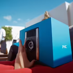 person holding up a small box on a couch