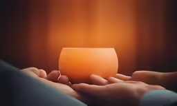 a person holds an orange bowl to the side