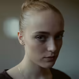 a woman with blond hair and wearing a brown dress