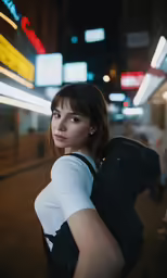 a girl with a backpack is on the street at night