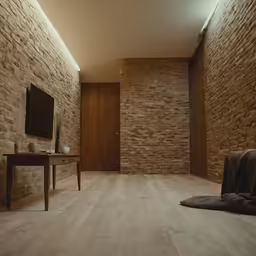 a living room with large stone walls and exposed wood floors