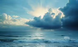 some clouds are over an ocean with waves