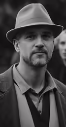 man wearing suit and hat at outdoor event