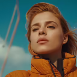 a woman in an orange coat and tan hat