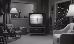 a tv sitting next to two chairs in a living room