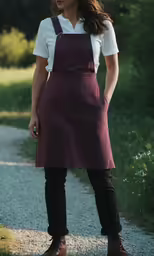 a woman in maroon and white uniform standing on dirt