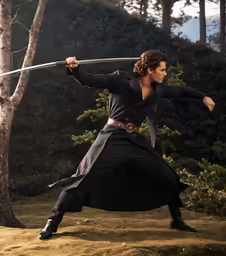 the man is practicing his sword skills on the hillside