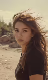 a beautiful woman with long hair standing on the beach