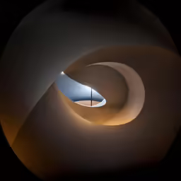 the dark background features a wavy shape and is illuminated by a light from the ceiling