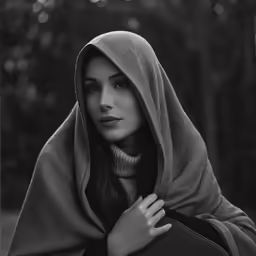 a woman wearing a hooded cape in black and white