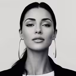 a woman with hoop earrings wearing a white shirt