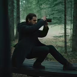 a man taking pictures in the woods with his camera
