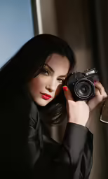 woman with red lipstick taking photo on camera