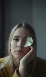 a woman sitting with her nose pressed against the side of her face