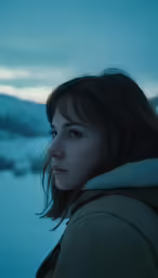 a woman stands on a snowy mountain top
