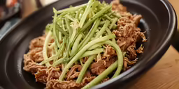an assortment of meat and green beans in a bowl
