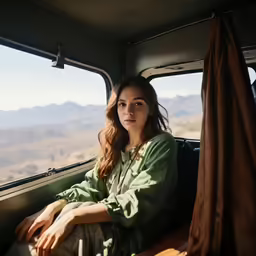 the woman is sitting in a van looking out the window