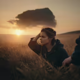 a woman in the middle of a field holding her head