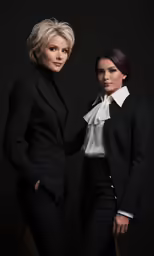 two women posing for a portrait in suit and tie