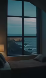 a bed sitting next to a window overlooking the ocean