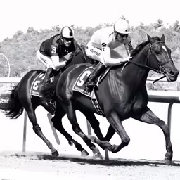 black and white photograph of two men racing horses