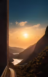 the sun is setting behind some mountains and a road