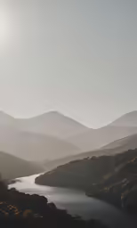 a sun is shining over the mountains near a lake