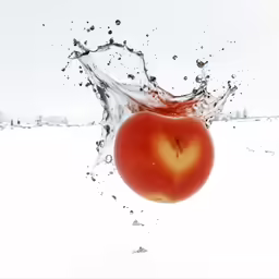 a red tomato is floating down on white snow