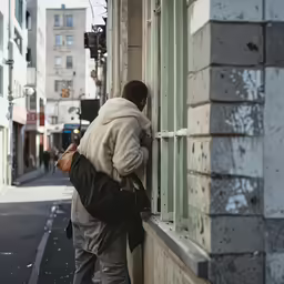 a person leaning on a window looking in at the outside