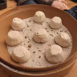 there are six desserts with some icing in the bowl