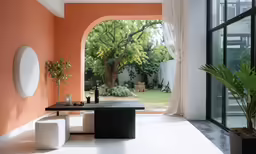 a living room with an orange wall, a table and chairs