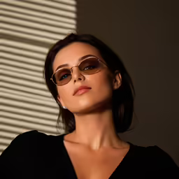 a woman wearing glasses in front of a window