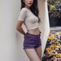 a woman with long brown hair wearing purple shorts and a short top