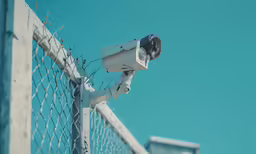a security camera that is on a fence